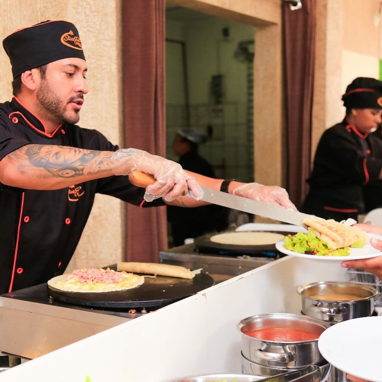 Chef Star Crepes servindo crepe com salada ao convidado